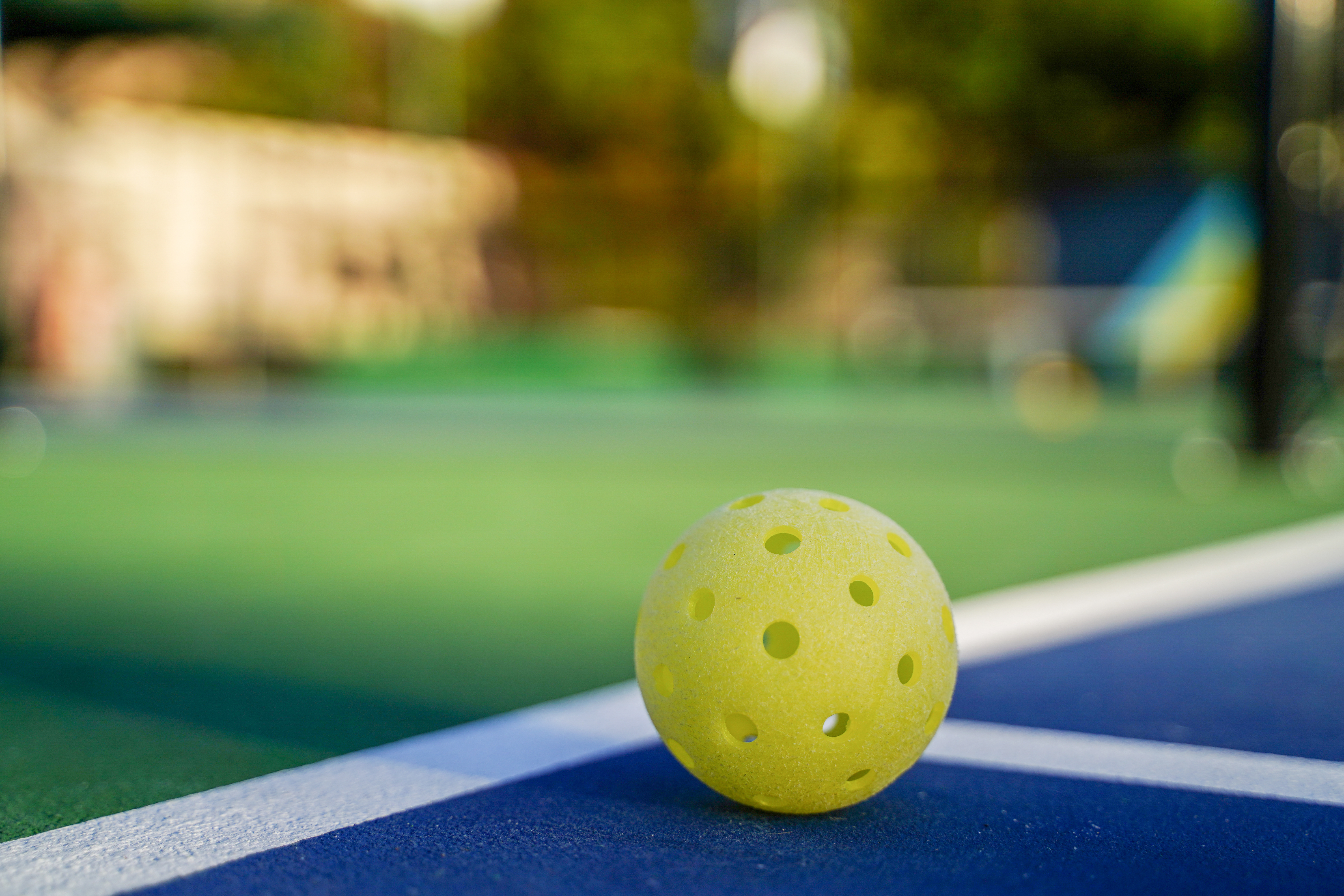 Pickleball ball ligt op een buitenvleld Pickleball ball ligt op een buitenvleld