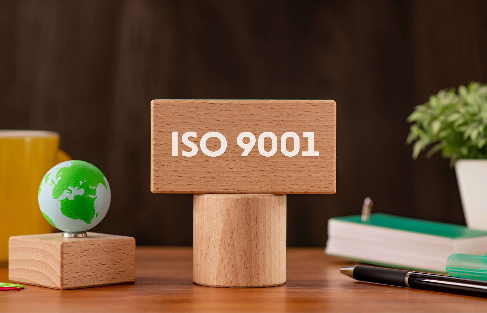 ISO 9001 auf Schreibtisch mit Erde