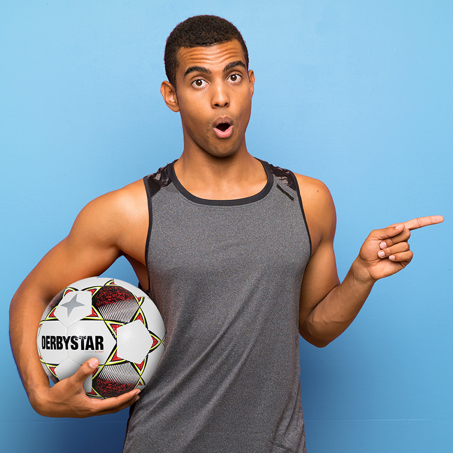 Jongeman houdt een Derbystar voetbalbal vast en wijst naar rechts